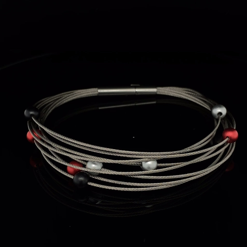 Video of Ursula Muller's Contemporary Red Grey Black Eight Row Aluminium Bracelet. Available on DESIGNYARD.com and in our Jewellery Shop Dublin, Ireland. Worldwide Shipping with DHL