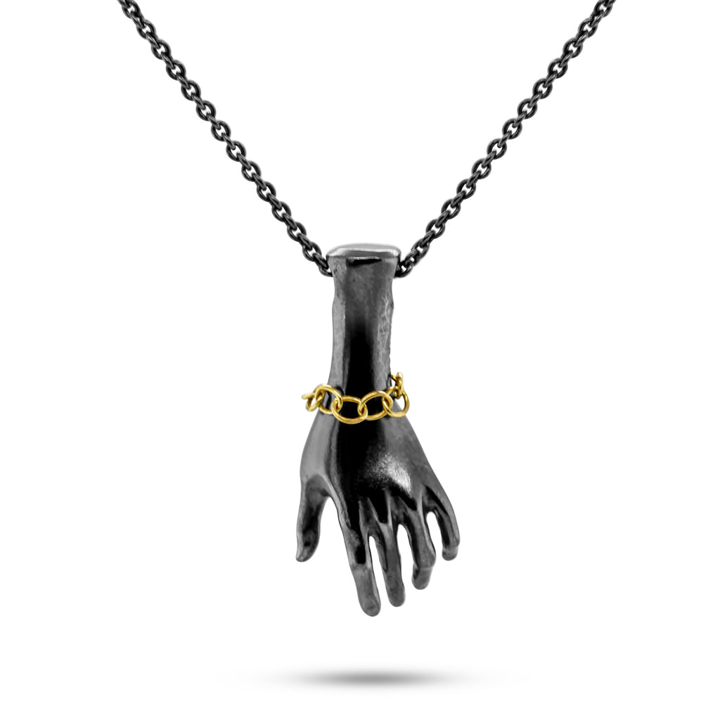 Photograph 1 of Sam Lafford's Contemporary Oxidised Silver Helping Hand with 9k Yellow Gold Bracelet Necklace. Available on DESIGNYARD.om and in our Jewellery Shop Dublin, Ireland. Free Worldwide Shipping with DHL.