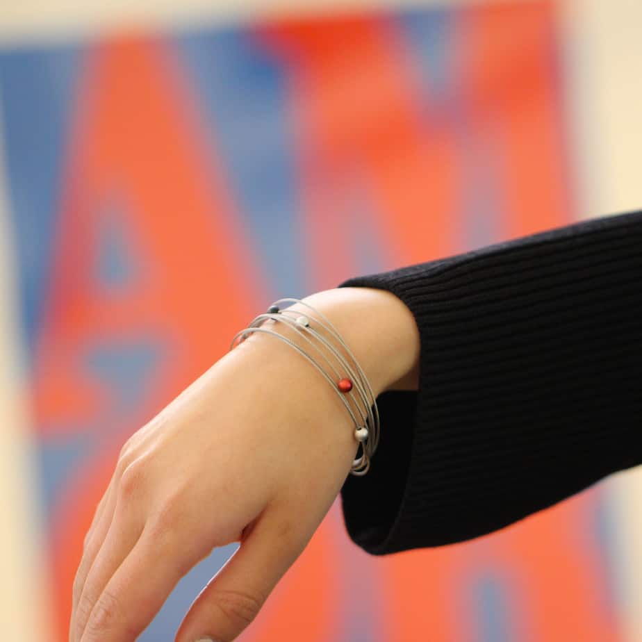 Photograph 2 of Ursula Muller's Contemporary Red Grey Black Eight Row Aluminium Bracelet. Available on DESIGNYARD.com and in our Jewellery Shop Dublin, Ireland. Worldwide Shipping with DHL