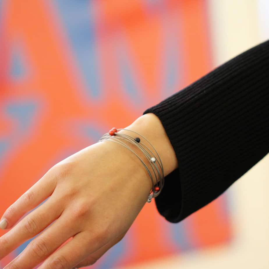 Photograph 3 of Ursula Muller's Contemporary Red Grey Black Eight Row Aluminium Bracelet. Available on DESIGNYARD.com and in our Jewellery Shop Dublin, Ireland. Worldwide Shipping with DHL
